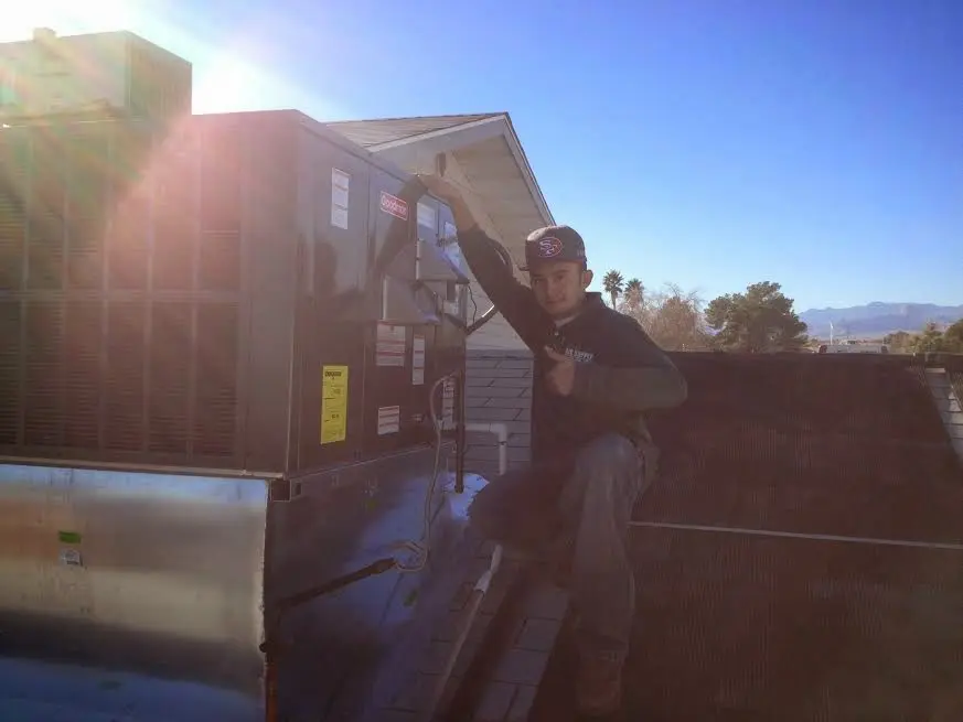 HVAC technician performing AC Tune-Up on a rooftop unit in Rocky River