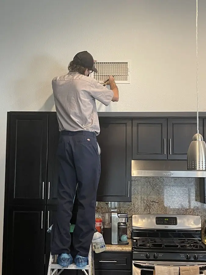 Technician inspecting an air vent during HVAC service in Rocky River